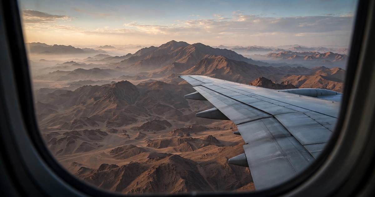 View over an aircraft wing above the mountains near Jeddah, where pilgrims enter ihram before crossing the miqat