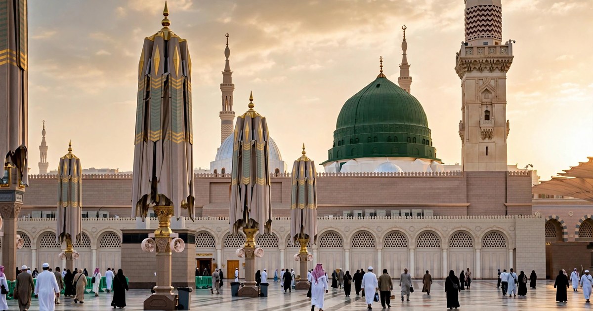 The green dome of the Prophet's Mosque in Madinah at golden hour with the courtyard umbrellas folded